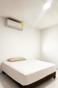 een witte slaapkamer met een bed en een witte muur bij Departamento Puerto Vallarta in Puerto Vallarta