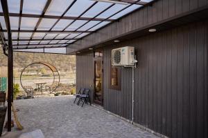 an outdoor patio with a fan and a table at Villa Marusya Gusar in Qusar