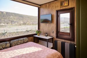 a bedroom with a bed and a window with a tv at Villa Marusya Qusar in Qusar