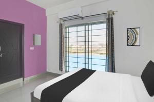 Un dormitorio con una cama y vistas a una piscina. en Super Hotel O Chikmangaluru Near Railway Station, en Chikmagalur