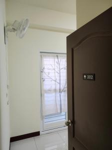 a door with a window in a room with a tree at 谷香 Guxiang House 東區靜巷透天獨棟 in Tainan