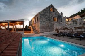a house with a swimming pool in front of a house at Villa Castella Verde in Rogoznica
