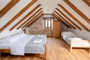 two beds in a attic room with wooden beams at Villa Castella Verde in Rogoznica +27 photos