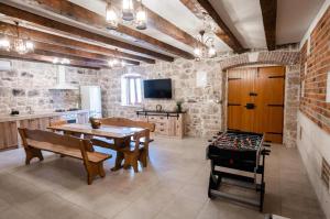 a large kitchen with a table and a game room at Villa Castella Verde in Rogoznica