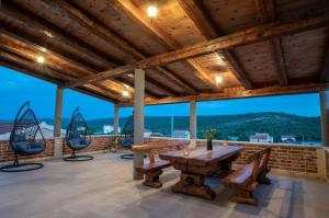 a patio with a wooden table and chairs on a roof at Villa Castella Verde in Rogoznica