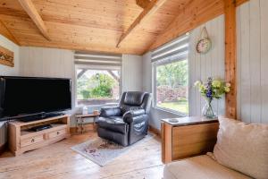 a living room with a television and a leather chair at 2 Bed in Keddington oc-t32411 in Louth