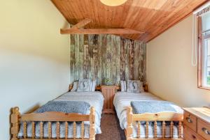 two beds in a room with a wooden ceiling at 2 Bed in Keddington oc-t32411 in Louth