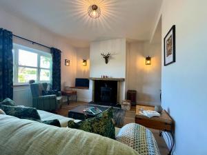 ein Wohnzimmer mit Couch und Kamin in der Unterkunft Cosy cottage near Saltburn & Whitby in Boosbeck