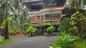 a building with a bunch of plants in front of it at lakeview homestay in Trikarpur