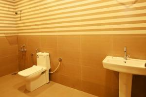 a bathroom with a toilet and a sink at Villa NirvanaPool4BHKPatioLawnACParty Villa in Hyderabad