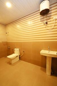 a bathroom with a toilet and a sink at Villa NirvanaPool4BHKPatioLawnACParty Villa in Hyderabad
