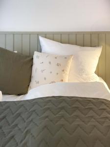 a bed with white sheets and pillows at Ferienwohnung 3, Schlaf-Gut-Johannis, Flensburg in Flensburg