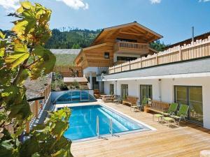 een huis met een zwembad op een houten terras bij Alpin-Chalet Flachauwinkl in Flachau