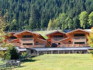 a large log cabin building in a field with trees at Alpin Chalet Flachauwinkl in Flachau