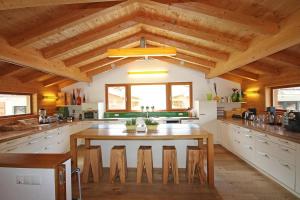 a large kitchen with a wooden ceiling and a table at Alpin Chalet Flachauwinkl in Flachau +12 photos