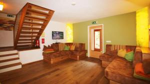 a living room with two couches and a staircase at Alpin Chalet Flachauwinkl in Flachau
