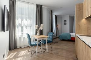 a hotel room with a table and chairs and a bed at P6-A Riga Old Town Apartments in Rīga