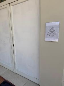 a white door with a sign on a wall at Sparrow s nest in Koropi
