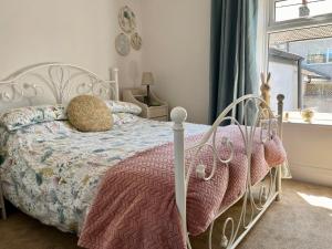 ein Schlafzimmer mit einem weißen Bett und einem Fenster in der Unterkunft Cosy cottage near Saltburn & Whitby in Boosbeck