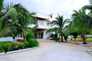 a house with palm trees in front of it at Agastya FarmsPoolAC4BHKParty Villa25 PaxWifi in Hyderabad