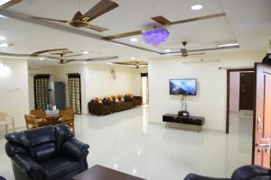 a living room with couches and a table and chairs at Agastya FarmsPoolAC4BHKParty Villa25 PaxWifi in Hyderabad