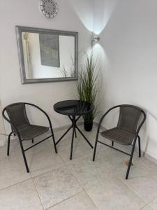 two chairs and a table in a room with a mirror at Sparrow s nest in Koropíon
