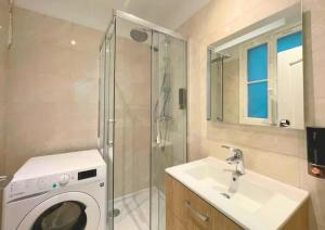 Un baño con lavadora y lavabo. en Cozy appart 15Mn Champs-Élysées, en París