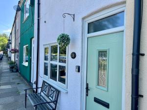 ein Gebäude mit einer Tür und einer Bank auf einem Bürgersteig in der Unterkunft Cosy cottage near Saltburn & Whitby in Boosbeck