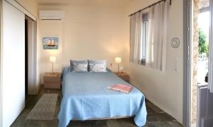 a bedroom with a blue bed and a window at Aigaion House in Otziás +70 photos