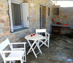 a white table and chairs on a stone patio at Aigaion House in Otziás