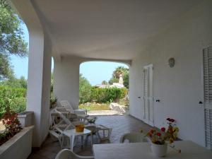 an outdoor patio with tables and chairs and an archway at Hotel Masseria Tutosa in Ostuni