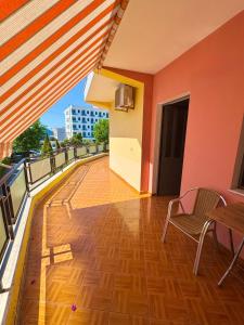 a balcony with a wooden floor and a table and chairs at Hotel Martini in Velipojë