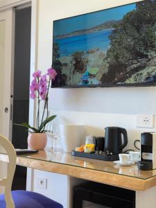 a table with a vase of flowers and a picture on the wall at Luxury l'Aurora Room in Castelsardo