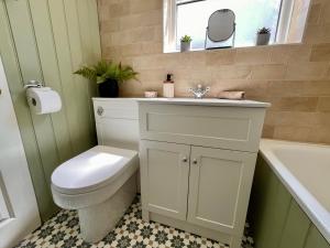 ein Badezimmer mit Toilette, Waschbecken und Badewanne in der Unterkunft Cosy cottage near Saltburn & Whitby in Boosbeck + 10 Fotos
