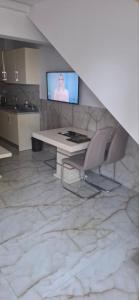 a living room with a table and chairs and a television at Alibaba in Olympiaki Akti