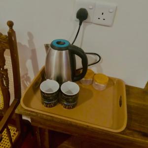 a tea kettle on a tray on a table at Ella Willow Cottage in Ella