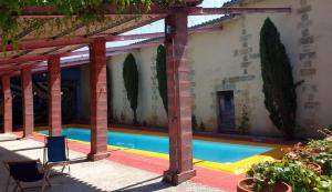 a swimming pool in a building with red columns at Hostel du chateau in Saint-Émilion