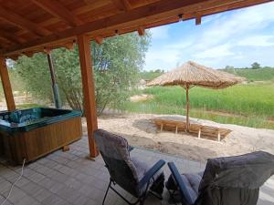 eine Terrasse mit einem Whirlpool und einem Sonnenschirm in der Unterkunft Domek Loft z Balią Jacuzzi i sauną na wyłączność Dowspuda 