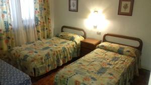 a bedroom with two beds and a lamp at Casa Saura Y in Benasque