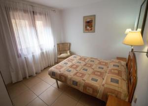 a bedroom with a bed and a lamp and a chair at Casa Saura Y in Benasque