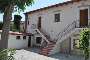 a staircase leading up to a white house with a tree at B&B Villa Marsico in Falerna