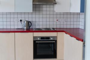una cucina con piano cottura e piano di lavoro rosso di Destiny Student - Parkgate a Dublino