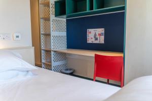 una camera da letto con una scrivania e una sedia rossa accanto al letto di Destiny Student - Parkgate a Dublino Altre 35 foto