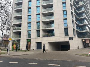 un hombre caminando delante de un gran edificio en Kawaii Apartments Pool&SPA Centrum Lublina, en Lublin
