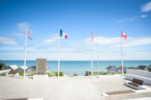 a view of the ocean from the beach at Maison Studios & Appartements Les 4 Vents in Luc-sur-Mer