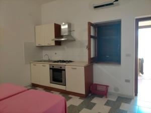 a room with a kitchen with a stove and a bed at Villaggio Athragon in Capo Vaticano