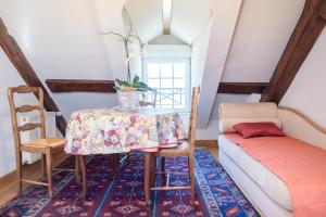 a dining room with a table and a couch at Maison Studios & Appartements Les 4 Vents in Luc-sur-Mer