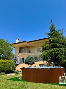 Una casa con piscina y un árbol delante de ella. en E L urban villa., en Epanomí