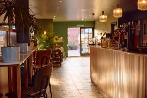a restaurant with a bar and tables and chairs at The White Hart Inn in West Mersea