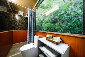a bathroom with a toilet and a large window at Tsunami bungalow in Cat Ba +42 photos